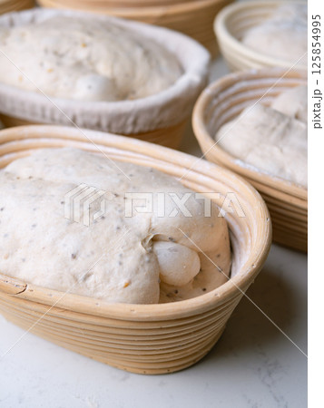 Sourdough Bread in Proofing basket, bannetons baskets for retarding raw dough before baking. 125854995