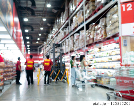 Defocused Blurred view of store worker safety work with folklift truck at warehouse hypermarket superstore store background. 125855203