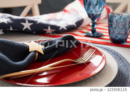 American table setting for USA Independence Day. Festive dinner decorated in USA national flag colors white, red and blue. Close up. 125856119