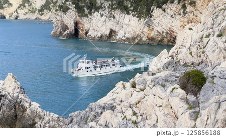 Tourist boat with passengers in bay of Porto Venere, Liguria. Tourists on sea transportation in Italy. Background for design.  125856188