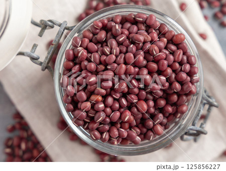 Glass jar full of azuki beans on gray top view. Dried uncooked legumes. Vegetarian protein 125856227
