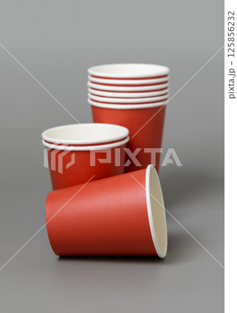 Disposable red paper cups on a gray closeup, mockup. No plastic and sustainable Christmas Disposable red paper cups on a gray closeup, mockup. No plastic and sustainable Christmas 125856232