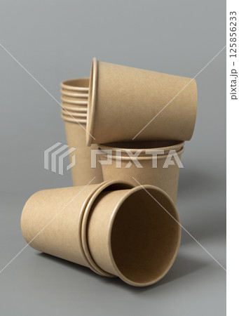 Disposable beige kraft paper cups on a gray closeup, mockup. No plastic and sustainable lifestyle Disposable beige kraft paper cups on a gray closeup, mockup. No plastic and sustainable lifestyle 125856233