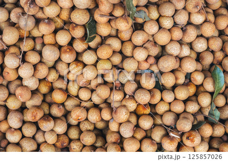 background with ripe longan. Exotic Asian fruits on counter in the market close-up 125857026