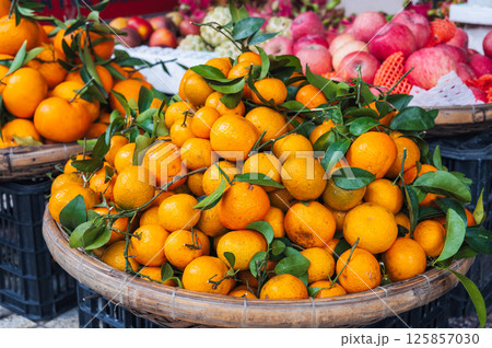 pile of fresh ripe sweet tangerines on the counter at a grocery market in Asia 125857030