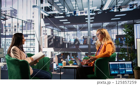 Female business leader in a professional office strategizing for development success, discussing with the main investor. Self accomplished women driving innovation and gender equality. Camera B. 125857259