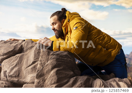Inexperienced tired trekker loses his footing in extreme conditions, struggling to keep his balance as he tumbles. Remote wilderness offers beauty but also grave risks, reckless. 125857469