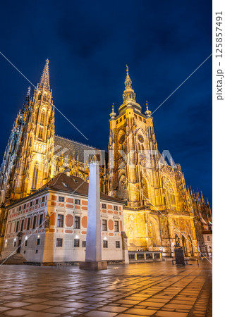 Under the starry sky, St Vitus Cathedral glows with golden lights, showcasing its stunning Gothic architecture. The surroundings are serene, inviting visitors to appreciate its beauty at night. 125857491