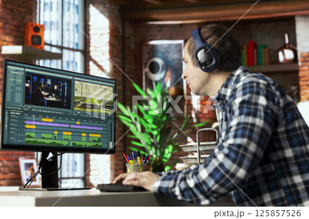 Video editor analyzing film montage on computer screen before editing color grading and lighting in creative home office. Post production studio employee working with raw footage on PC Video editor analyzing film montage on computer screen before editing color grading and lighting in creative home office. Post production studio employee working with raw footage on PC 125857526