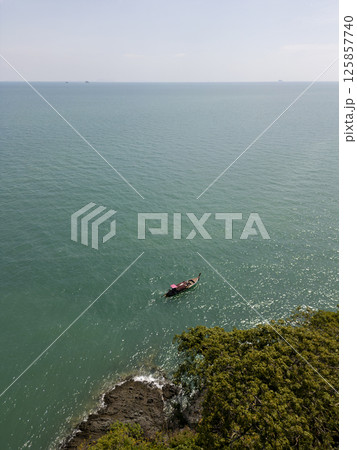 Aerial view of a stunning small Thai island with sailboats around the shore, amazing travel destination featuring crystal clear waters and dense rainforests. Tropical landscape. 125857740