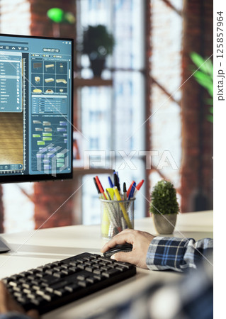 Interior designer uses architectural software to generate virtual photorealistic image renderings. Man preparing visual preview for customers after designing room with 3D modeling application 125857964