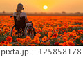 young woman sits in a wheelchair wearing headphones and listening to music. 125858178