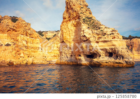 Coastal rocky seascape. Rocky shore near Praia da Marinha beach and Benagil in Algarve region in Atlantic ocean, Portugal, Europe 125858780