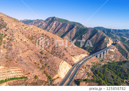 View from above Mountain landscape with viaduct. Honey Viaduct on Mediterranean Highway. Viaducto del Miel on Autovia del Mediterraneo. Malaga, Spain 125858782