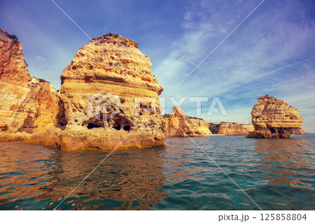 Coastal rocky seascape. Rocky shore near Praia da Marinha beach and Benagil in Algarve region in Atlantic ocean, Portugal, Europe Coastal rocky seascape. Rocky shore near Praia da Marinha beach and Benagil in Algarve region in Atlantic ocean, Portugal, Europe 125858804