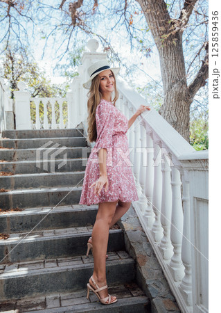 woman in summer pink dress and hat on street smiling woman in summer pink dress and hat on street smiling 125859436