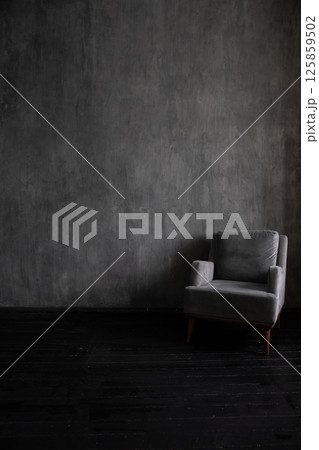 Old armchair in the interior of a dark gray room 125859502
