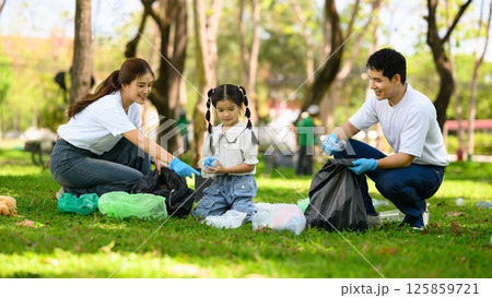 Happy family picking up litter together in a park for environmental conservation Happy family picking up litter together in a park for environmental conservation 125859721