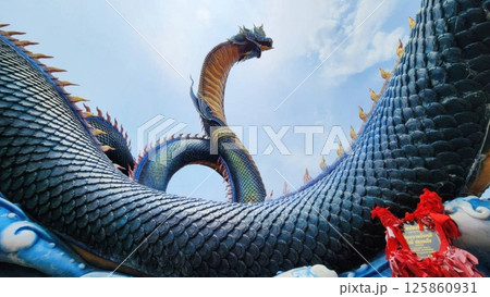 Majestic Dragon Sculpture Against Clear Blue Sky in Vibrant Colors Majestic Dragon Sculpture Against Clear Blue Sky in Vibrant Colors 125860931