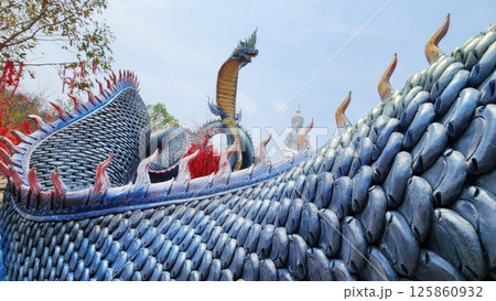 Majestic Dragon Sculpture on Temple Roof in Clear Blue Sky 125860932