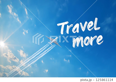 A jet airplane makes a contrail spelling out "Travel More" against a vibrant blue sky. Evoking the spirit of travel, adventure, and exploration. For travel-themed promotions or inspirational visuals. 125861114