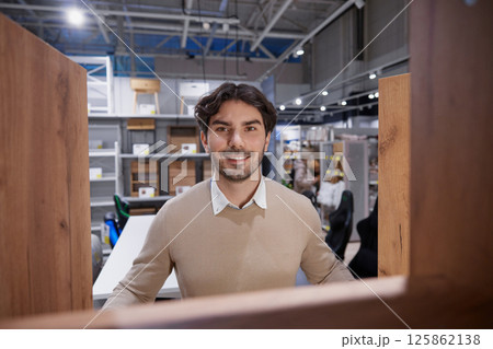 Man stands confidently with bright smile embodying success in modern, contemporary work environment 125862138