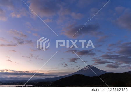 Textured clouds illuminated by the fading sunlight, while Mount Fuji silhouette rises below 125862183