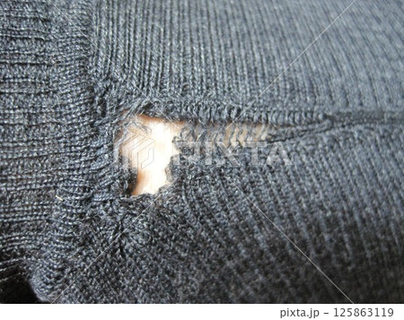 虫に食われた穴から裂けたウールのセーター 125863119