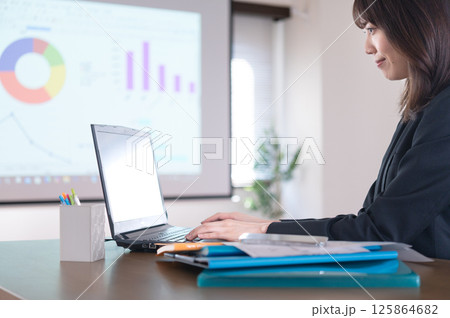仕事するスーツ姿の若い女性 125864682