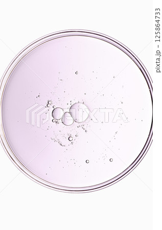 The texture of a cosmetic serum or body gel in a Petri dish. 125864733