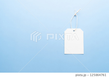 Blank tag label with string on light blue background. Mock up for design. 125864761