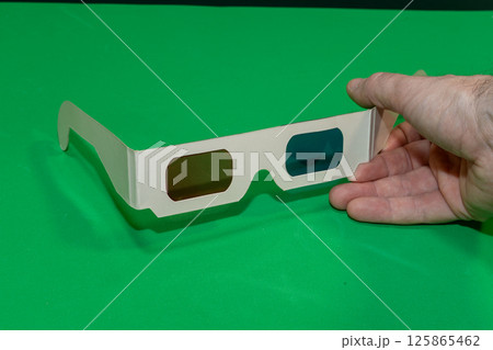 A Hand Holding 3d Glasses for Cinema with a Chroma Background 125865462