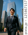 晴天のビジネス街で新生活を始める新入社員の男性 125867157