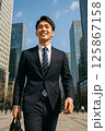 晴天のビジネス街で新生活を始める新入社員の男性 125867158