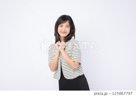 Southeast asian woman smiling warmly in striped jacket posing happily for advertising with clean white background and natural expression Southeast asian woman smiling warmly in striped jacket posing happily for advertising with clean white background and natural expression 125867797