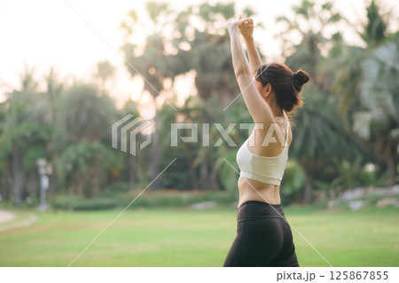 Southeast asian woman enjoying healthy lifestyle concept as she exercises outdoors in lush green park, embracing wellness and relaxation in morning light Southeast asian woman enjoying healthy lifestyle concept as she exercises outdoors in lush green park, embracing wellness and relaxation in morning light 125867855