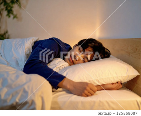 ベッドで心地よく眠る日本人男性のリラックスポートレート 125868087