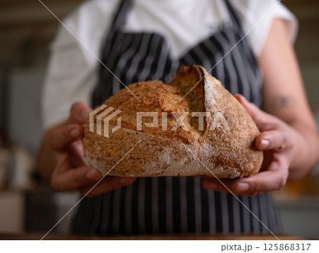 Artisan Sourdough Bread in Hand - Fresh from the Oven. Artisan Sourdough Bread in Hand - Fresh from the Oven. 125868317