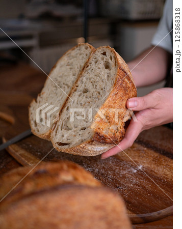 Artisan Sourdough Bread in Hand - Fresh from the Oven. Artisan Sourdough Bread in Hand - Fresh from the Oven. 125868318
