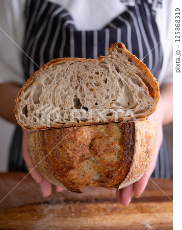 Baker Presenting Homemade Sourdough. Baker Presenting Homemade Sourdough. 125868319