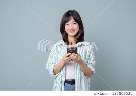Southeast asian woman smiles while using smartphone for her small business online store showing creative startup ideas in retail industry with confident shopping skills Southeast asian woman smiles while using smartphone for her small business online store showing creative startup ideas in retail industry with confident shopping skills 125868526
