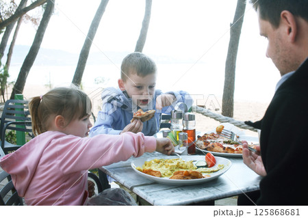 happy family eating pizza in cafe outside, lifestyle people 125868681