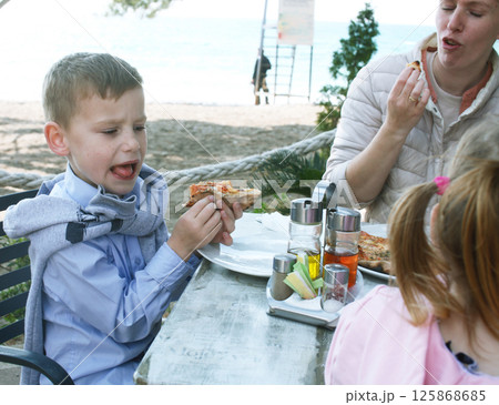 happy family eating pizza in cafe outside, lifestyle people happy family eating pizza in cafe outside, lifestyle people 125868685