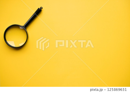 Top view of magnifying glass on yellow background, space for text. Search concept Top view of magnifying glass on yellow background, space for text. Search concept 125869631