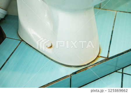 Messy toilet in a dirty bathroom. Dirty joints between the tiles in the bathroom. Unclean toilet, yellow stains Messy toilet in a dirty bathroom. Dirty joints between the tiles in the bathroom. Unclean toilet, yellow stains 125869662