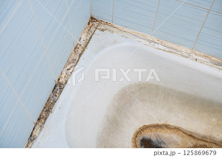 Old dirty bathroom. The bathtub is attacked by mold Old dirty bathroom. The bathtub is attacked by mold 125869679
