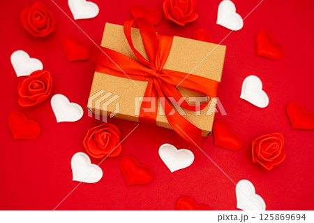 Gift box on the red background. Red ribbon. The concept of the day of St. Valentine's, weddings, birthday and other holidays Gift box on the red background. Red ribbon. The concept of the day of St. Valentine's, weddings, birthday and other holidays 125869694