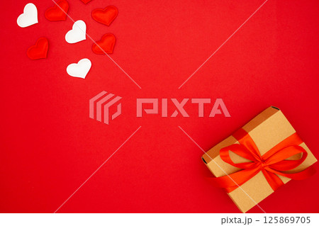 Beautiful gift box and hearts on red background, flat lay with space for text Beautiful gift box and hearts on red background, flat lay with space for text 125869705