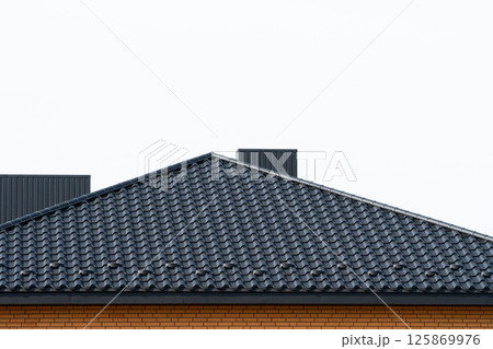 Roof structure covered with black metal tiles. Modern types of roofing materials. Modern housing construction 125869976