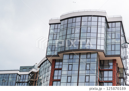 Modern apartment building. Multi Storey modern, new and stylish living block of flats. Fragment of a new elite residential building or commercial complex 125870189